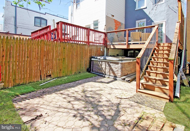 view of patio with fence, stairs, and a deck