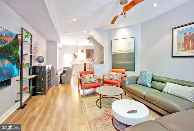 living area featuring light wood-style floors, a ceiling fan, and recessed lighting