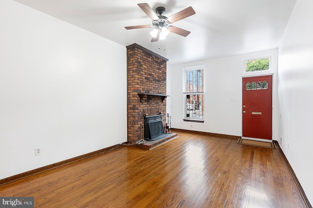 3403 Toone St, Baltimore, MD 21224 - unfurnished living room with wood finished floors, a ceiling fan, a brick fireplace, and baseboards