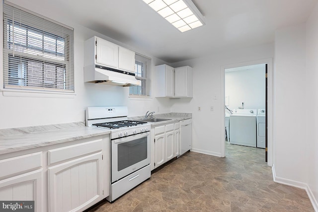 3403 Toone St, Baltimore, MD 21224 - kitchen with white appliances, under cabinet range hood, independent washer and dryer, stone finish floors, and a sink