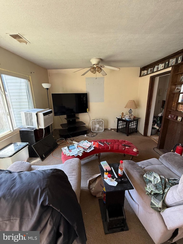 living room with visible vents, a ceiling fan, a textured ceiling, and carpet