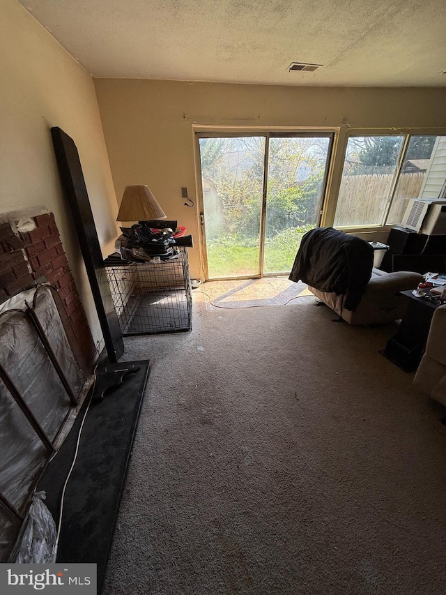carpeted living room with a textured ceiling and visible vents