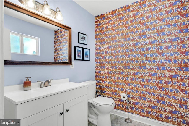 bathroom featuring vanity, wood finished floors, and toilet
