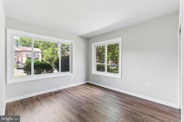 unfurnished room featuring dark wood finished floors and baseboards