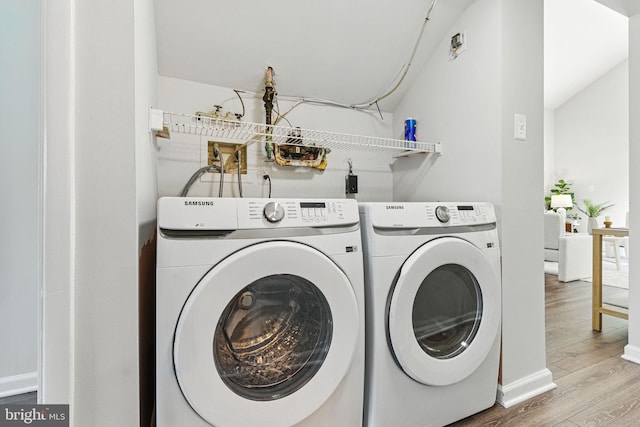 laundry area featuring washer and clothes dryer, wood finished floors, and baseboards