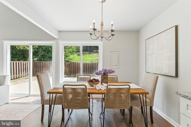 dining room featuring a chandelier, baseboards, and wood finished floors