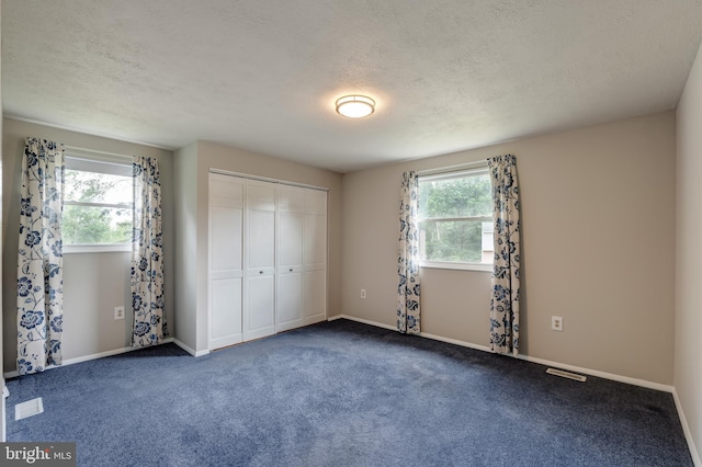 15926 Uppsala Ct, Woodbridge, VA 22191 - unfurnished bedroom featuring a textured ceiling, a closet, baseboards, and carpet flooring