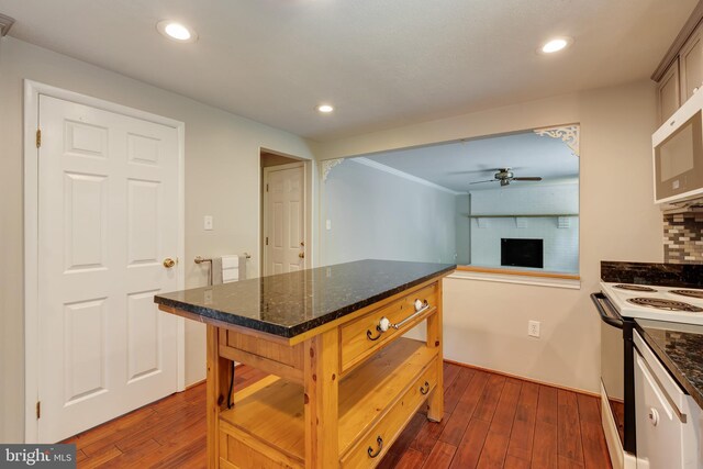 15926 Uppsala Ct, Woodbridge, VA 22191 - kitchen featuring white appliances, ceiling fan, dark wood finished floors, a fireplace, and dark stone counters