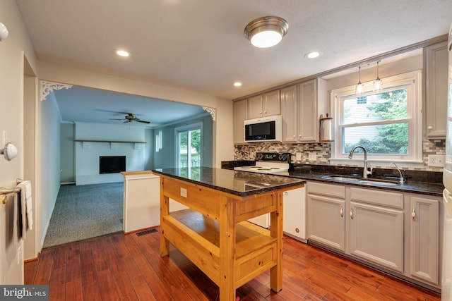 15926 Uppsala Ct, Woodbridge, VA 22191 - kitchen featuring a sink, white appliances, a fireplace, dark wood finished floors, and recessed lighting