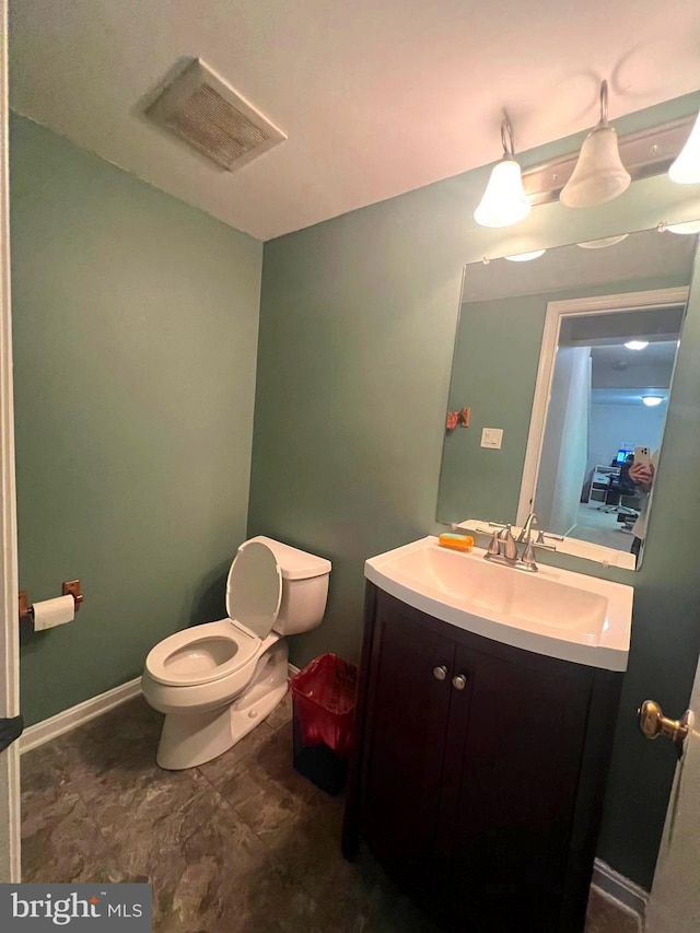 half bathroom with toilet, baseboards, visible vents, and vanity