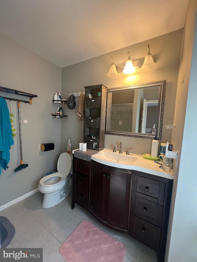 bathroom featuring vanity, baseboards, tile patterned floors, and toilet