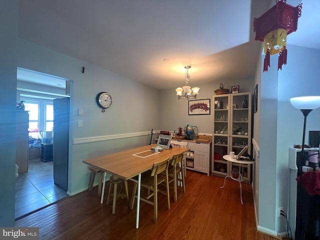 dining room with a notable chandelier and dark wood-style floors