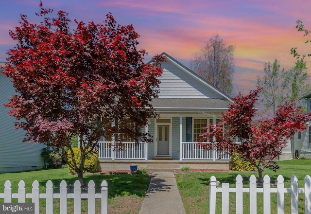 view of front of home featuring a porch, fence private yard, and a front lawn