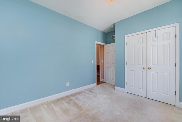 unfurnished bedroom with baseboards, carpet, visible vents, and a closet
