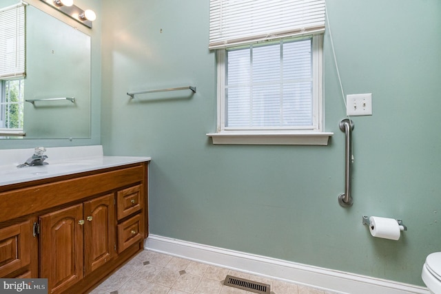bathroom with visible vents, baseboards, tile patterned floors, vanity, and toilet