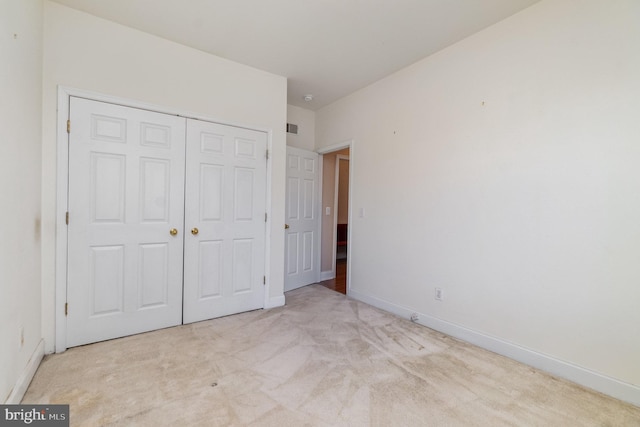 unfurnished bedroom featuring a closet, baseboards, carpet floors, and visible vents