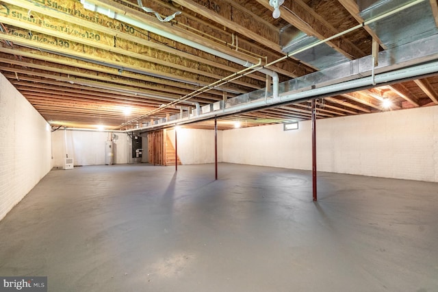 unfinished below grade area featuring heating unit and water heater