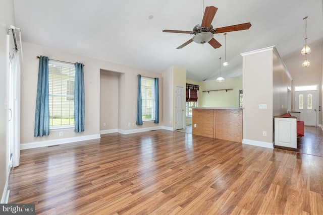 unfurnished living room featuring ceiling fan, a wealth of natural light, and wood finished floors