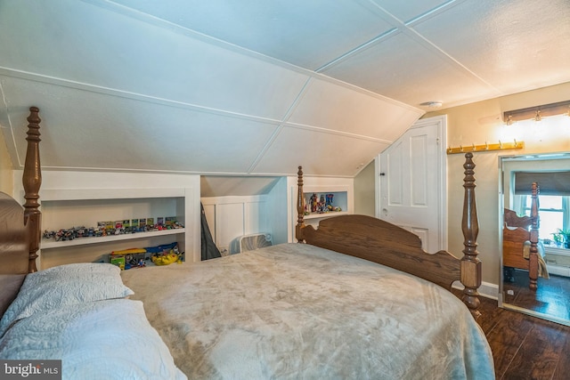 bedroom with baseboards, wood finished floors, and lofted ceiling