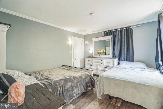 bedroom featuring crown molding and wood finished floors