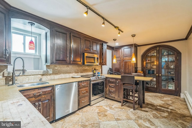 kitchen with a sink, appliances with stainless steel finishes, decorative backsplash, and light countertops