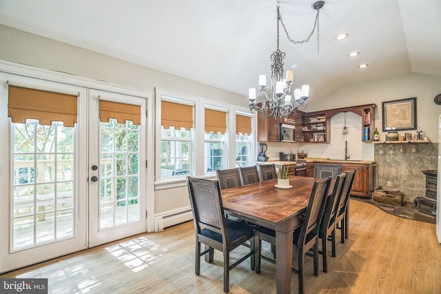 dining space featuring an inviting chandelier, lofted ceiling, recessed lighting, light wood-type flooring, and a baseboard radiator