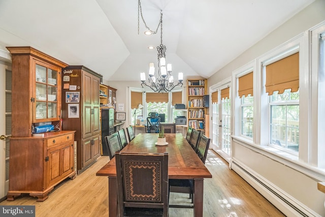 dining space featuring an inviting chandelier, baseboard heating, light wood-type flooring, and lofted ceiling