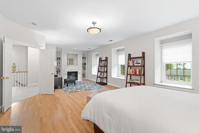 3929 Vacation Ln, Arlington, VA 22207 - bedroom with multiple windows, light wood-type flooring, baseboards, and a fireplace