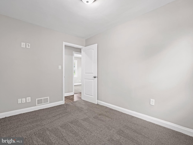 spare room featuring carpet floors, baseboards, and visible vents