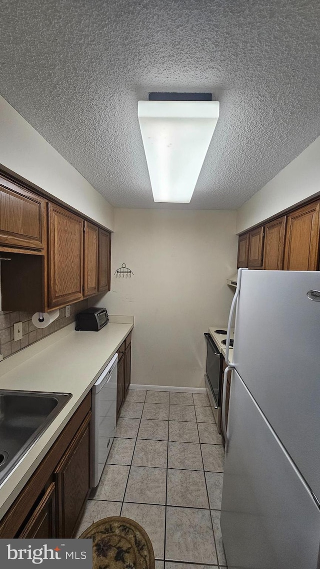 815 Ravens Crest Dr, Plainsboro, NJ 08536 - kitchen featuring white appliances, a textured ceiling, a sink, light countertops, and light tile patterned flooring
