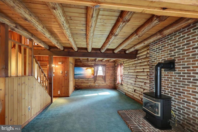 unfurnished living room featuring a wood stove, rustic walls, carpet floors, wooden ceiling, and beamed ceiling