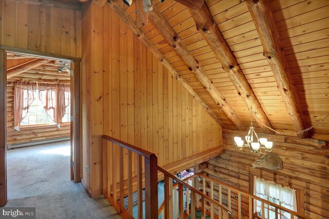 interior space featuring wooden walls, a baseboard heating unit, wooden ceiling, and vaulted ceiling with beams