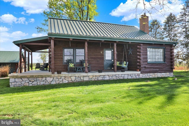 back of property featuring a yard, a chimney, and log siding
