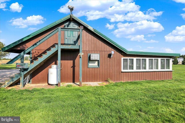 rear view of house featuring a yard and stairway