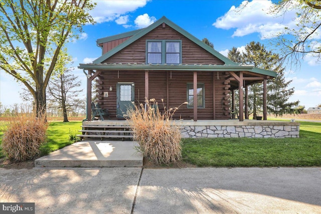 view of front of house with a porch, a front yard, and log exterior