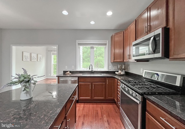 42667 New Dawn Ter, Brambleton, VA 20148 - kitchen with stainless steel appliances, a sink, wood finished floors, dark stone counters, and recessed lighting