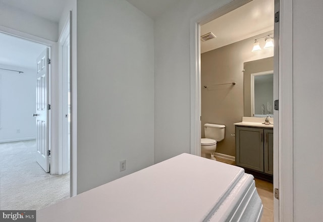 42667 New Dawn Ter, Brambleton, VA 20148 - bedroom featuring ensuite bathroom, a sink, baseboards, and light carpet