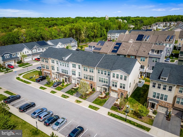 bird's eye view featuring a residential view and a wooded view