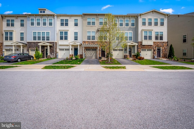 view of property featuring a residential view, an attached garage, driveway, and stone siding