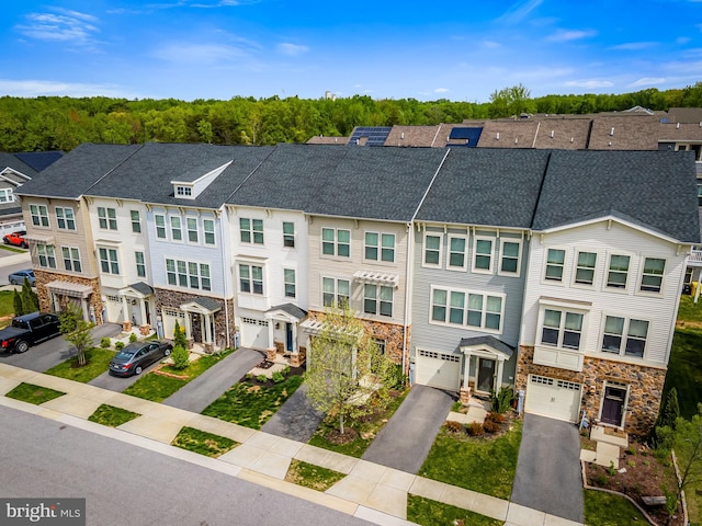 view of property featuring a residential view, a shingled roof, driveway, and stone siding