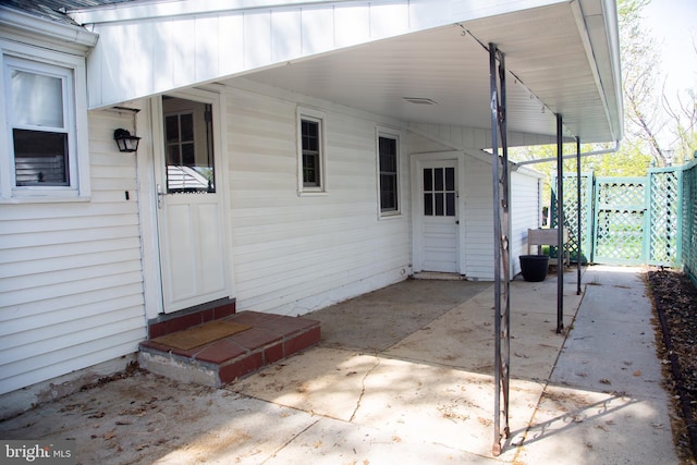 view of patio / terrace featuring fence and a carport