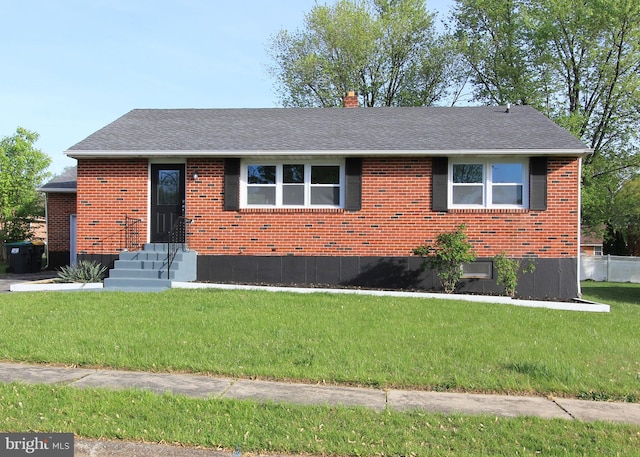 single story home with brick siding, a shingled roof, a front yard, and a chimney
