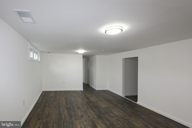below grade area featuring baseboards, dark wood finished floors, and visible vents