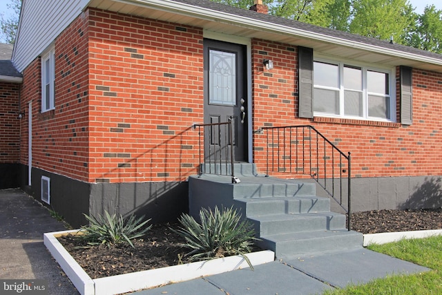 doorway to property featuring brick siding