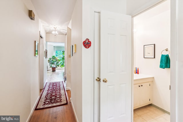 hall with baseboards and light wood-style flooring
