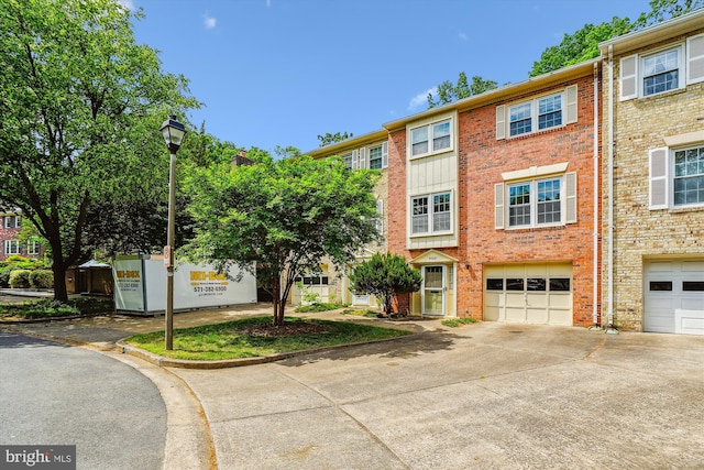 view of property with a garage and driveway