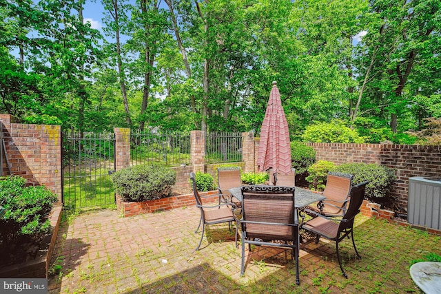 view of yard with central AC, a patio area, outdoor dining space, and fence