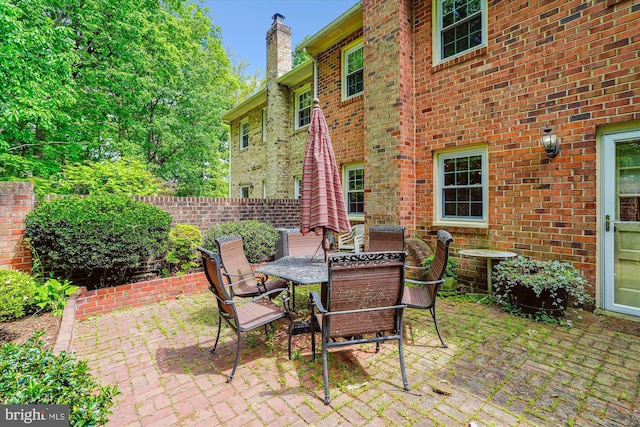 view of patio featuring central AC unit, fence, and outdoor dining space
