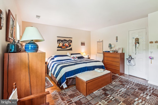 bedroom featuring visible vents and wood finished floors