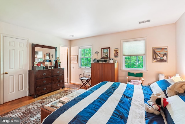 bedroom with visible vents and wood finished floors
